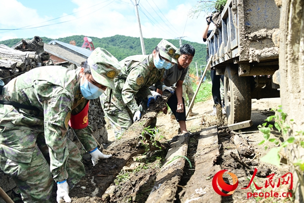 8月15日，北部战区陆军某旅参与黑龙江省牡丹江市宁安市沙兰镇二吕村灾后重建工作，图为该旅党员突击队正在清理杂物。任家宝 摄