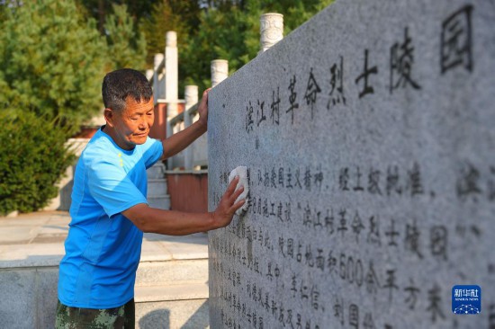 在辽宁省丹东市振兴区滨江村，村民擦拭滨江村革命烈士陵园石碑（2022年9月26日摄）。新华社记者 杨青 摄