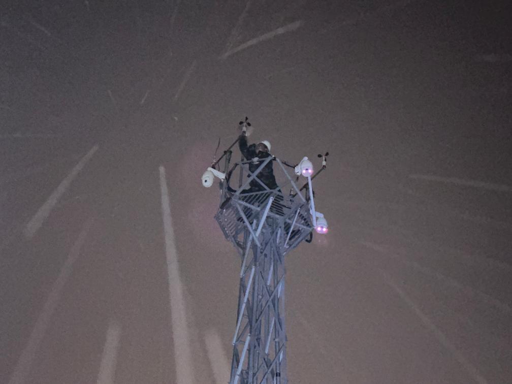 11月5日夜间,库伦旗气象部门工作人员冒着风雪爬上风塔,排除风速传感器故障。(受访者供图)