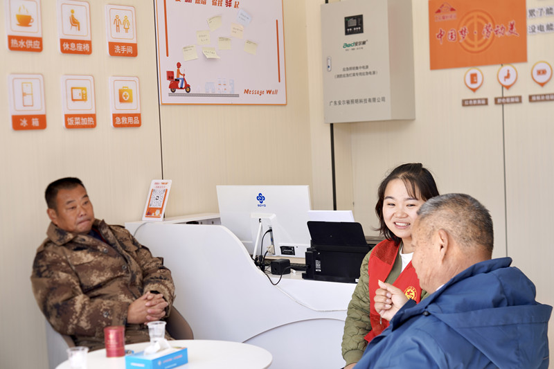 驿站工作人员和前来歇脚的群众交流沟通。殷洁摄