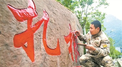 上图：杨洋为连队“扎根石”描红。刘乙举摄
