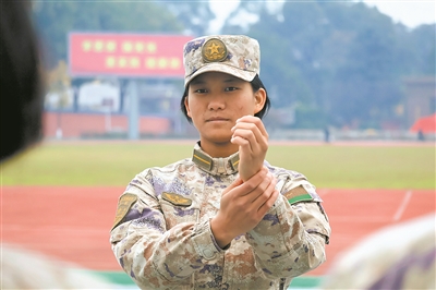 图①：丁王英讲解齐步走手型动作要领。刘锦澎摄