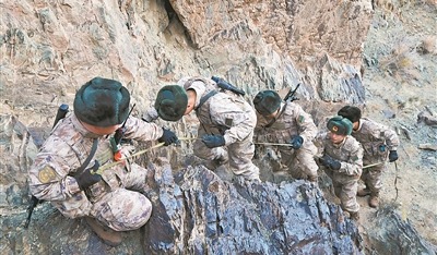 图②:官兵互帮互助,一同攀爬陡峭山坡。