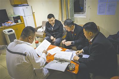 图②:法官向船长讲解相关法律规定,查看船舶资料,并与船方办理扣押船舶的手续。