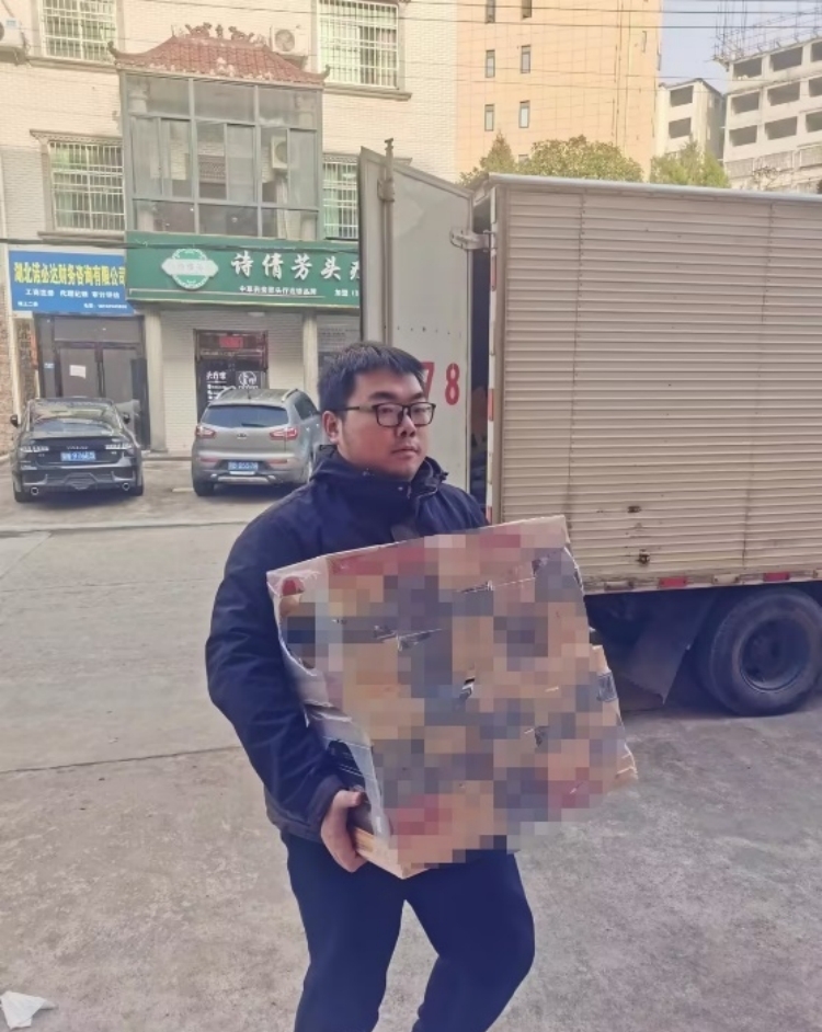 机关人员刘原枫在帮忙送货。