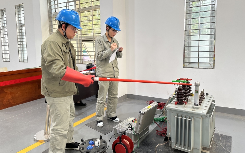 国网荆州变电检修分公司“望海计划”实习员工观摩220千伏笔架山变电站开关机构大修及间隔扩建现场，辨识相关变电设备。罗亭然摄