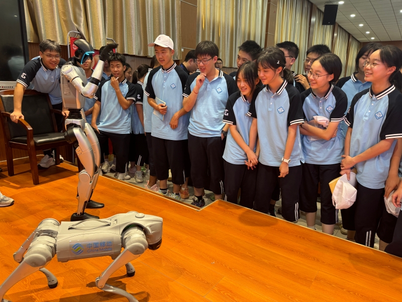 学生们在“开学第一课”与智能机器人、机器狗互动。