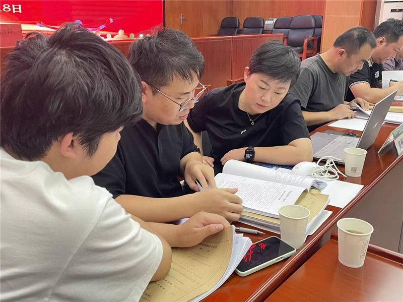 案卷评查活动现场评查人员仔细阅读案卷。蔡婧摄