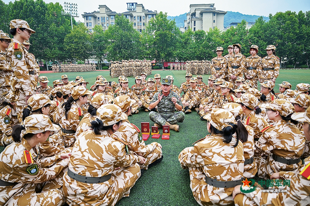 武警重庆总队机动支队为驻地高校开展军训时，穿插组织国防教育活动。图为一级上士安俊吉为学生们讲述所获奖章、纪念章背后的故事。本报特约通讯员  王  肸摄