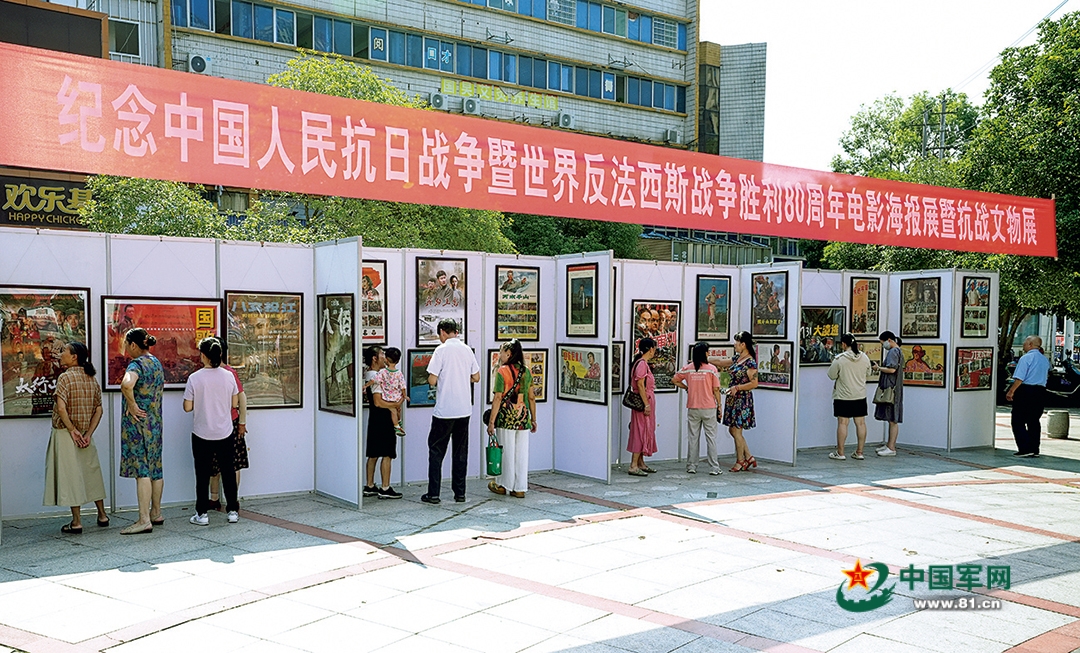 江西省上高县举办纪念中国人民抗日战争暨世界反法西斯战争胜利80周年电影海报展暨抗战文物展，市民驻足观展。邝小文摄