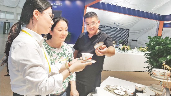 华光国瓷工作人员在向观展市民介绍新推出的“好运连连”中秋礼系列产品。