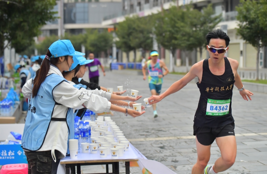 志愿者为跑友提供物资保障。天门市委宣传部供图