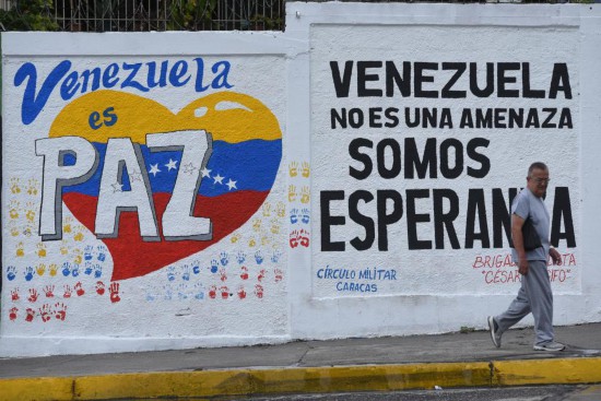 9月22日,在委内瑞拉首都加拉加斯,行人从街头的宣传标语前走过。标语上写着“委内瑞拉是和平国度”“委内瑞拉不是威胁,而是希望”。新华社发(马科斯·萨尔加多摄)