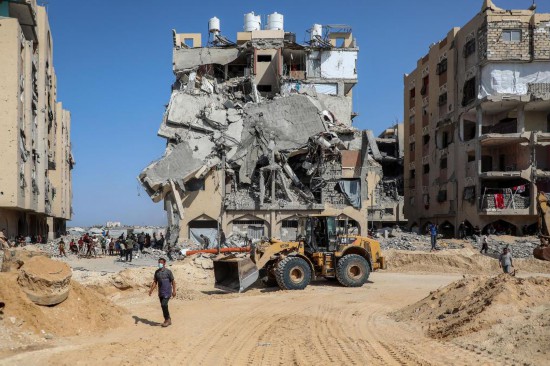 10月17日,司机驾驶装载机在加沙地带汗尤尼斯清理街道,搜寻遇难者。新华社发(里泽克·阿卜杜勒贾瓦德摄)