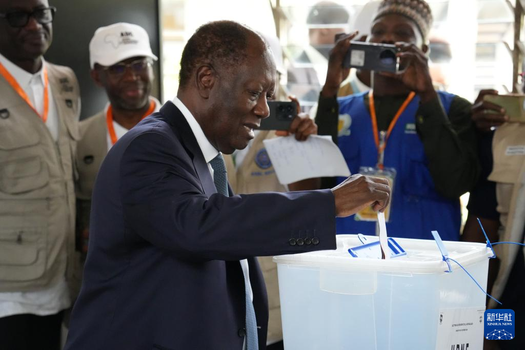 10月25日,在科特迪瓦经济首都阿比让的一处投票站,科特迪瓦现任总统阿拉萨内·瓦塔拉将选票放入投票箱。新华社记者 张健 摄