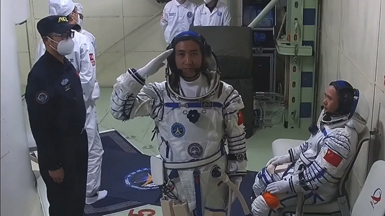 武飞即将进入神舟二十一号,正在向观众敬礼。央视视频截图