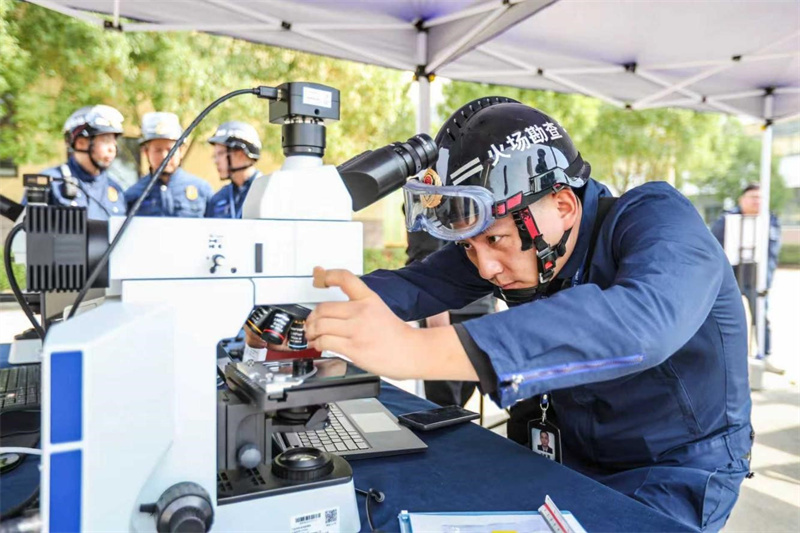 金相显微镜下正在开展痕迹物证分析，通过微观特征锁定电气火灾的关键证据。杨璇摄
