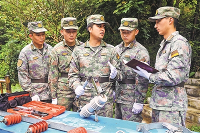 火箭军某部电力连连长杨康(左三)正在为战士讲解专业操作。刘乙举摄