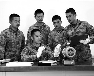 火箭军某旅某营高级技师、一级军士长毛伟（左二）正向班组战友讲解装备组件原理。本报特约通讯员 李 昌摄