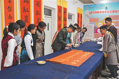 11月6日,信息支援部队工程大学通信士官学校“红岩雪鹰”宣传队队员在重庆西藏中学宣讲后,与师生一起参与学校书法社团活动。 谌世鑫摄