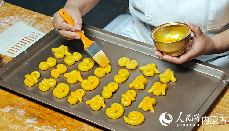 马家“精点心”制作技艺传承人马利给制作的糕点刷蛋液。人民网记者 张雪冬摄