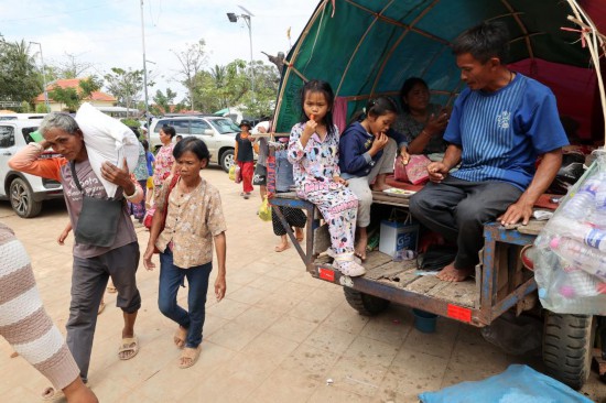 12月11日,在柬埔寨暹粒省一处居民安置点,人们领取救济物资后返回。新华社发(索万纳拉摄)